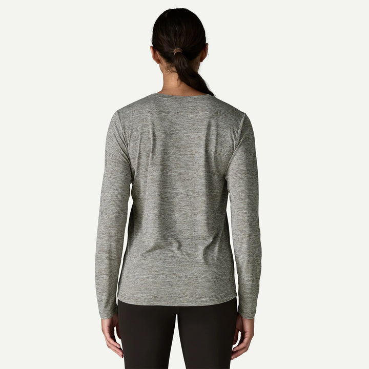 Person wearing a gray long-sleeve athletic shirt on a white background