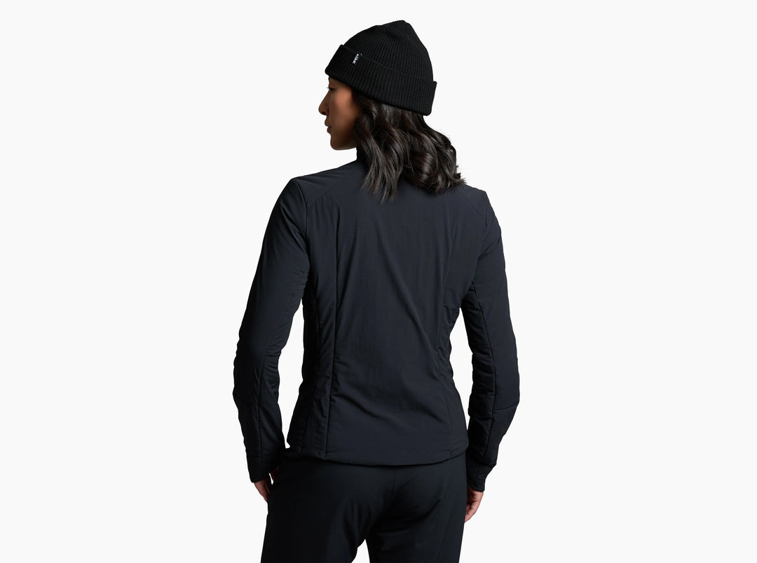 Woman in a black jacket looking away from the camera against a white background