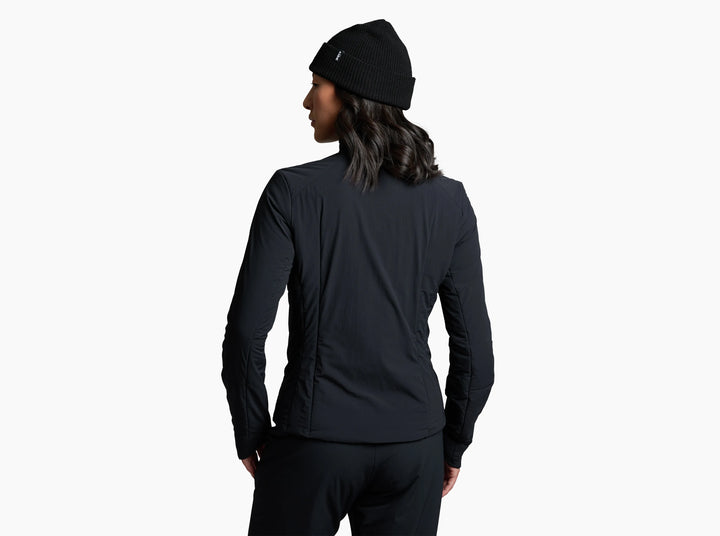 Woman in a black jacket looking away from the camera against a white background