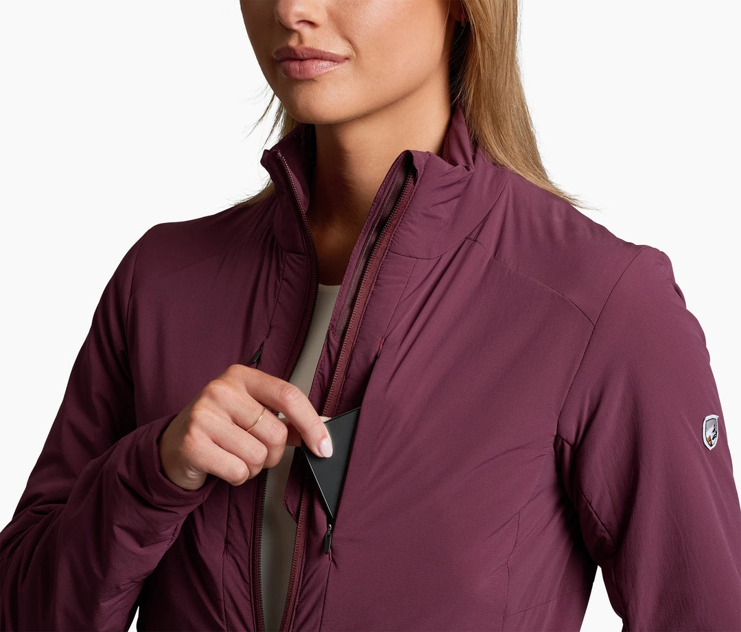 Woman wearing a wine coloured jacket, removing something from a chest pocket