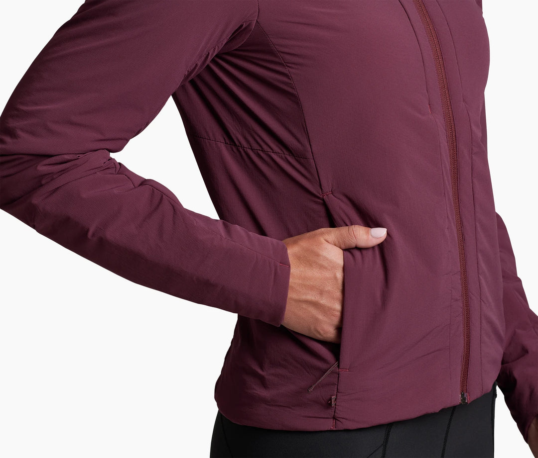Torso of a person wearing a wine coloured jacket, one hand in pocket