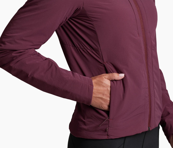 Torso of a person wearing a wine coloured jacket, one hand in pocket