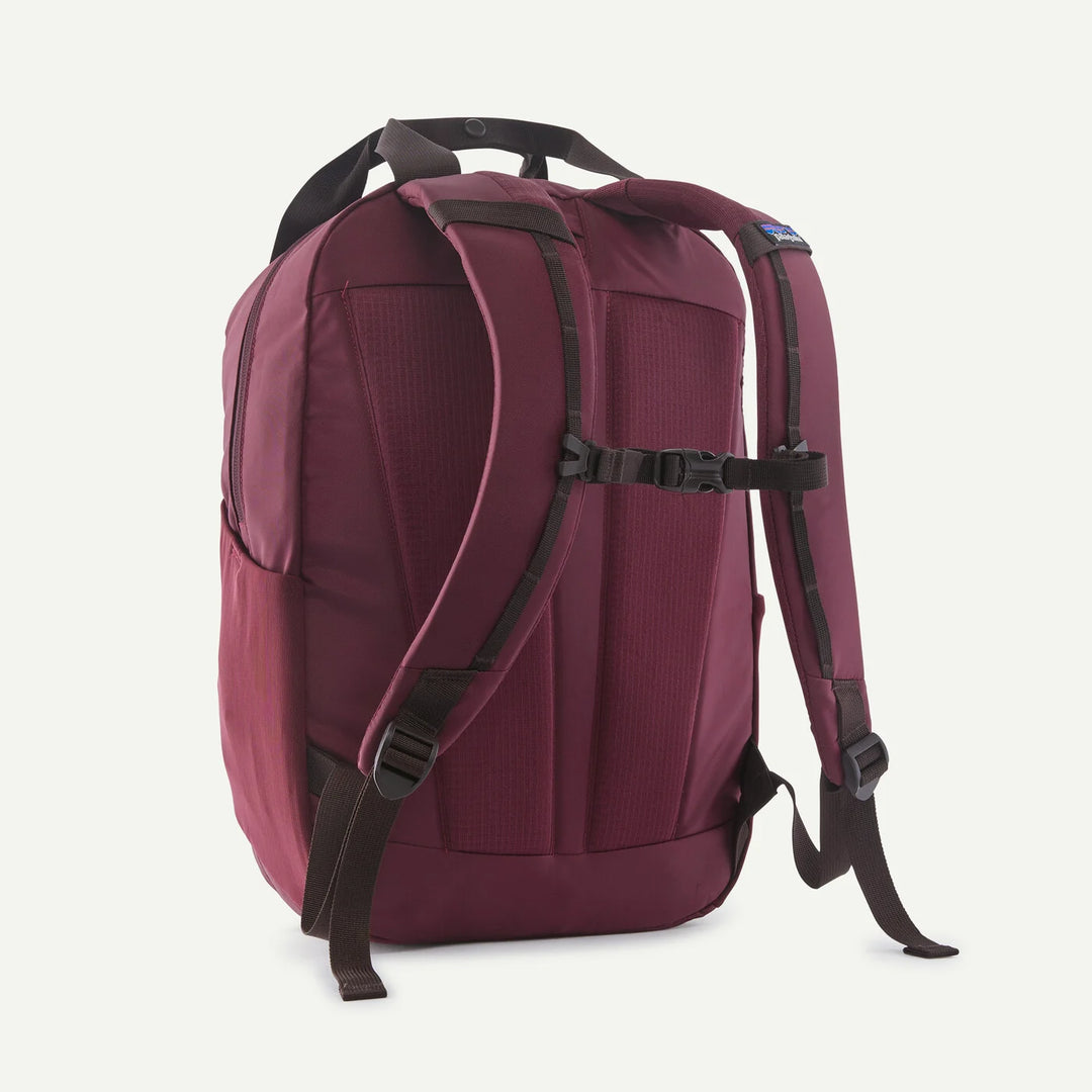 A burgundy Patagonia backpack shown from the back, featuring dark brown padded shoulder straps and buckles, set against a plain off-white background.