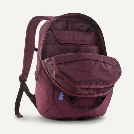 A maroon backpack with a large front zippered pocket and an open top compartment, shown on a white background. The brand name "patagonia" is visible in blue on the lower front pocket.