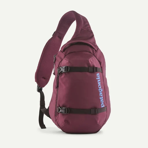 A Patagonia single-strap sling backpack in burgundy with black straps and a light blue Patagonia logo on the side, shown against a light off-white background.