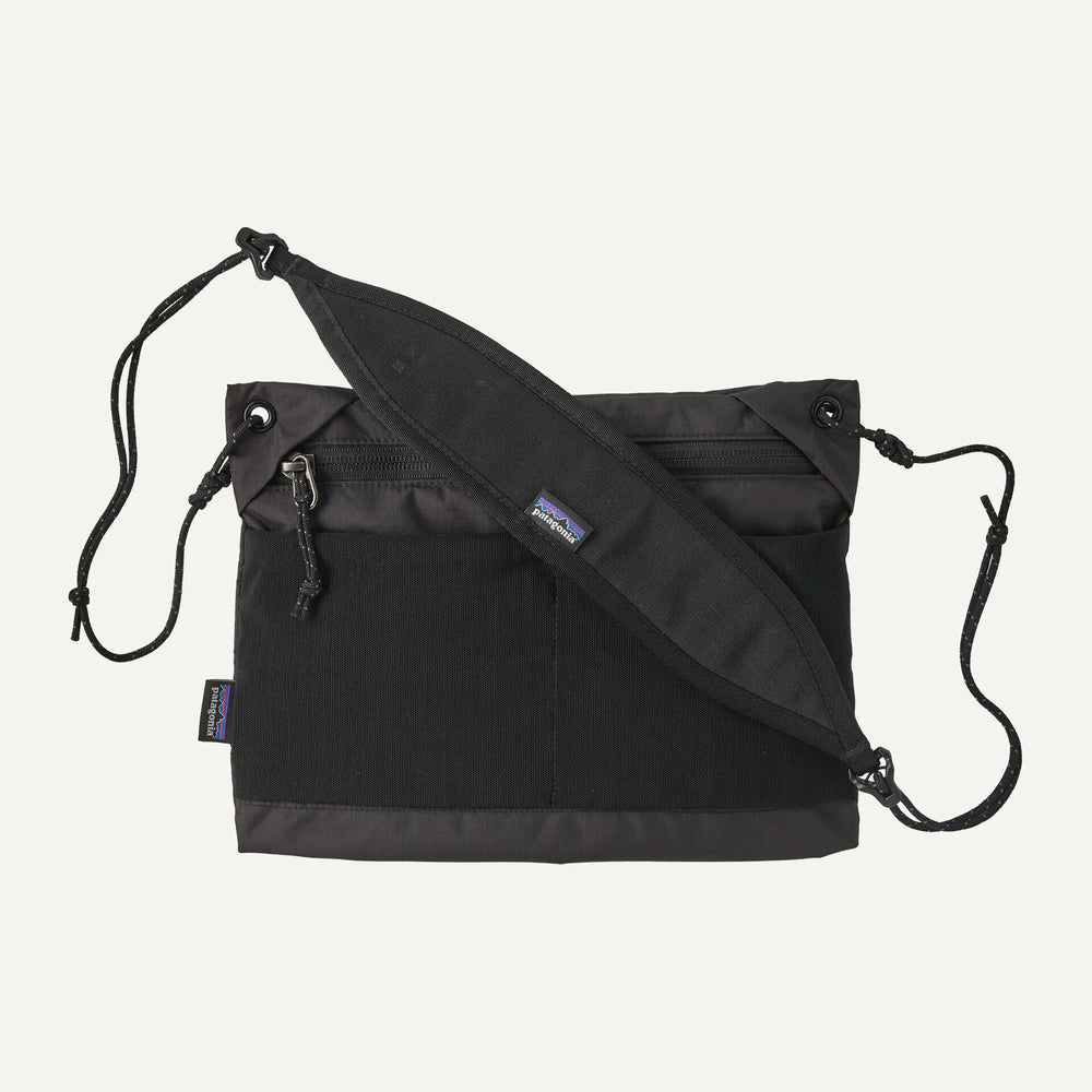 Black crossbody bag with a visible brand logo on a white background