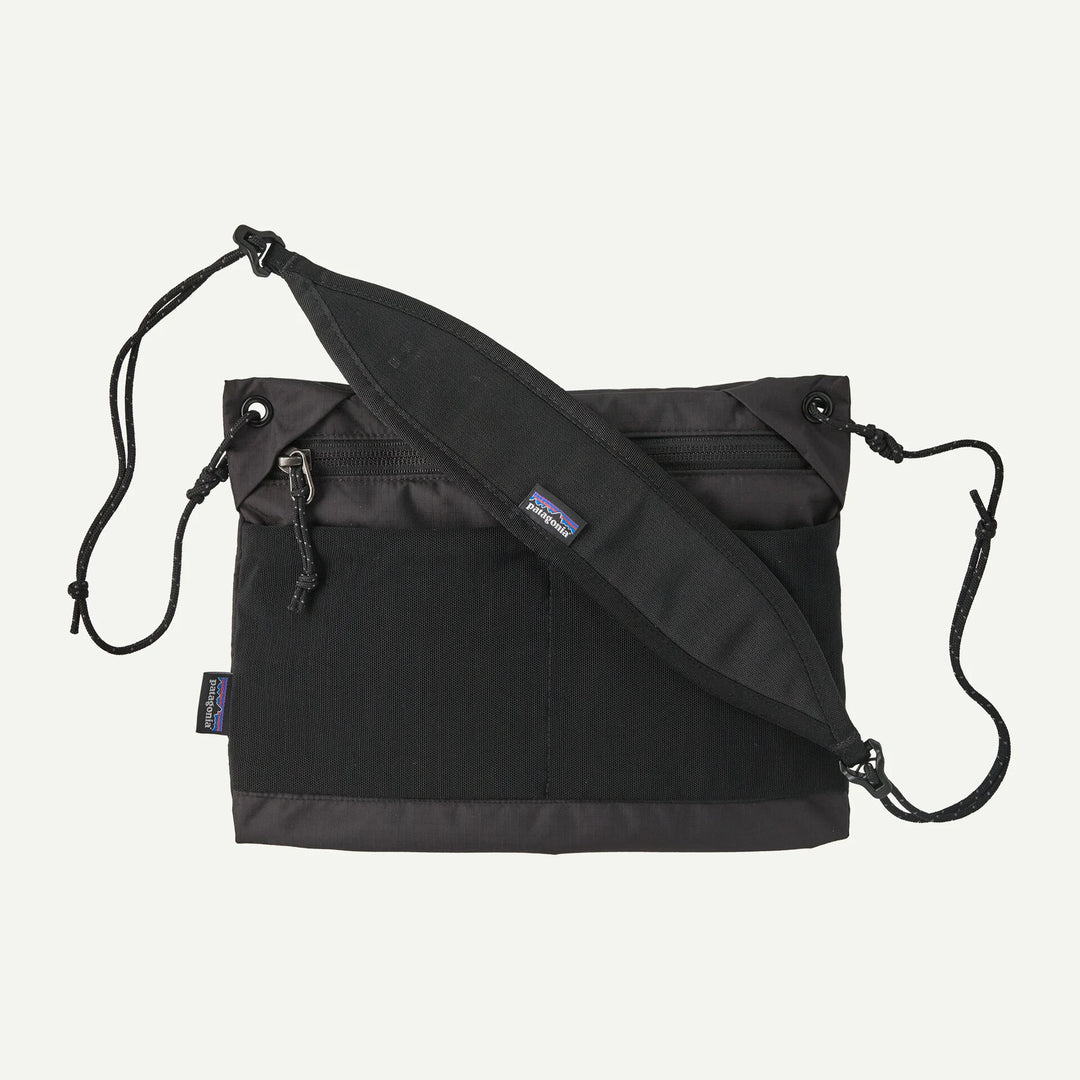 Black crossbody bag with a visible brand logo on a white background