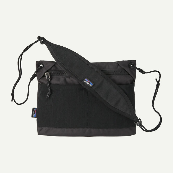 Black crossbody bag with a visible brand logo on a white background