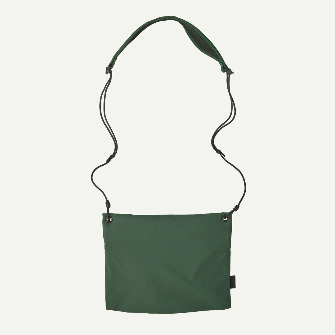A dark green canvas shoulder bag with an adjustable, detachable black cord strap, shown against a plain white background.