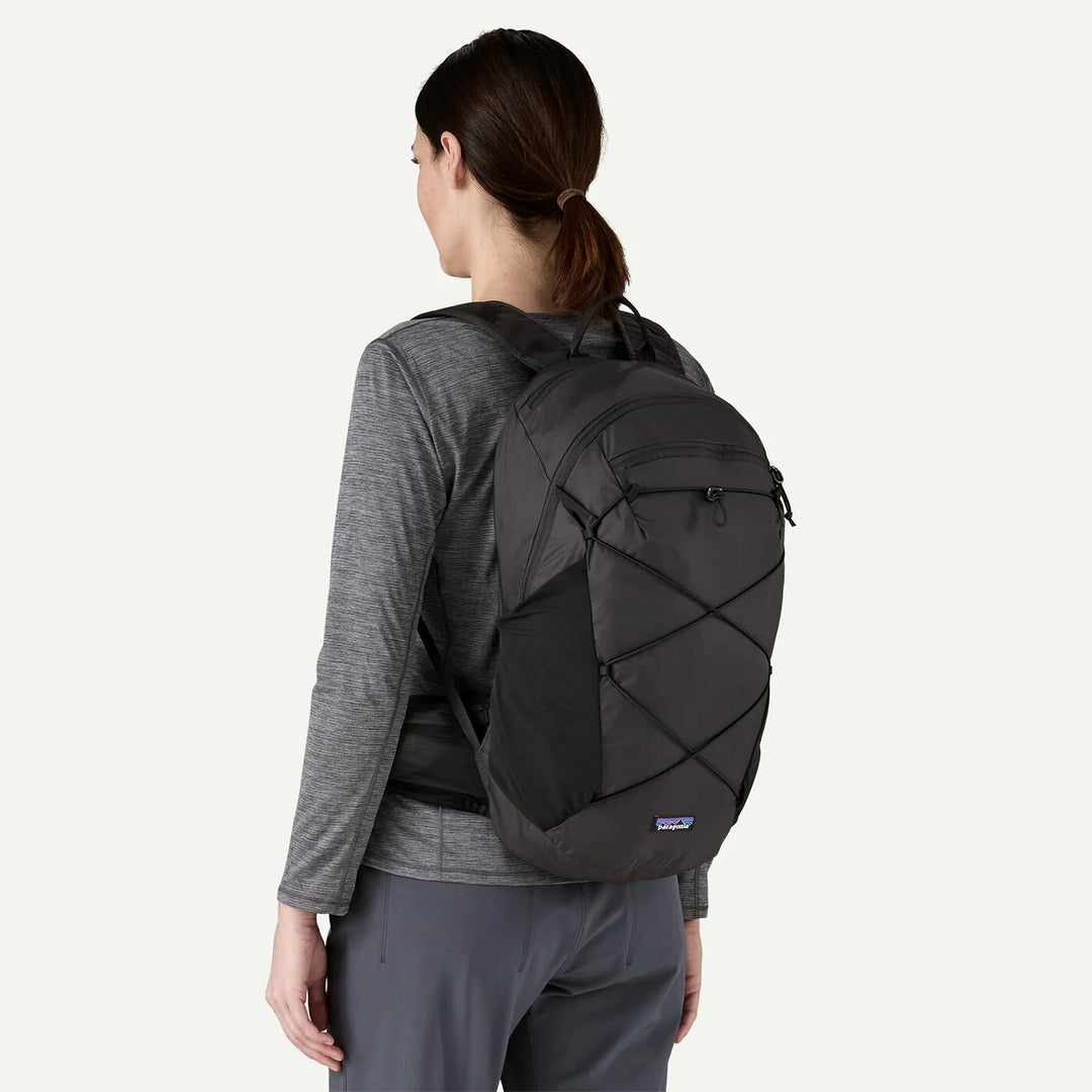 Person wearing a black backpack on a white background