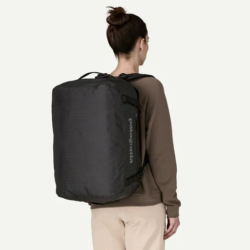 Person wearing a black Patagonia backpack on a white background