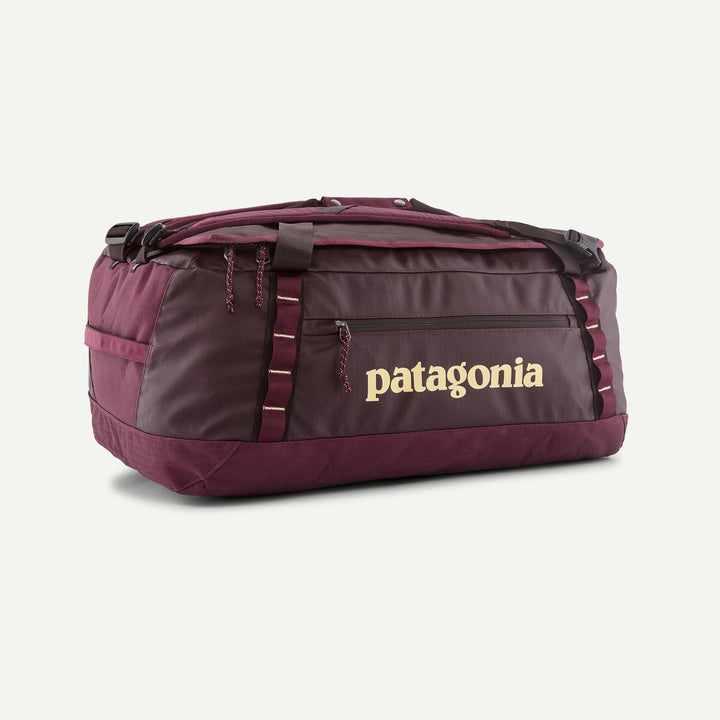 A Patagonia duffel bag in maroon and dark gray with a gold Patagonia logo on the front, shown on a plain white background.