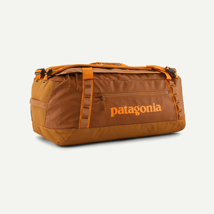 A brown and orange Patagonia duffel bag with the brand name printed in orange on the front, set against a light off-white background.