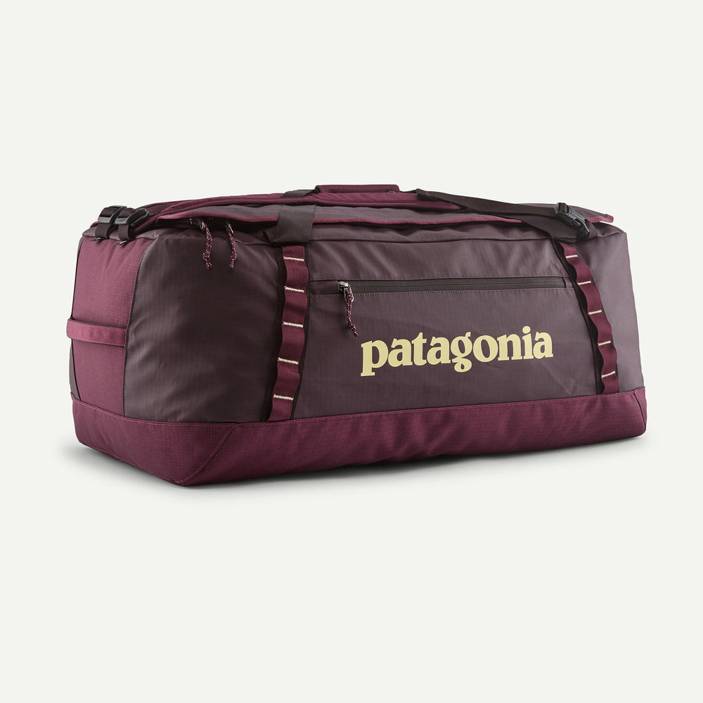 A Patagonia duffel bag in a deep burgundy color, featuring a gold Patagonia logo on the front pocket and matching burgundy straps, set against a light off-white background.