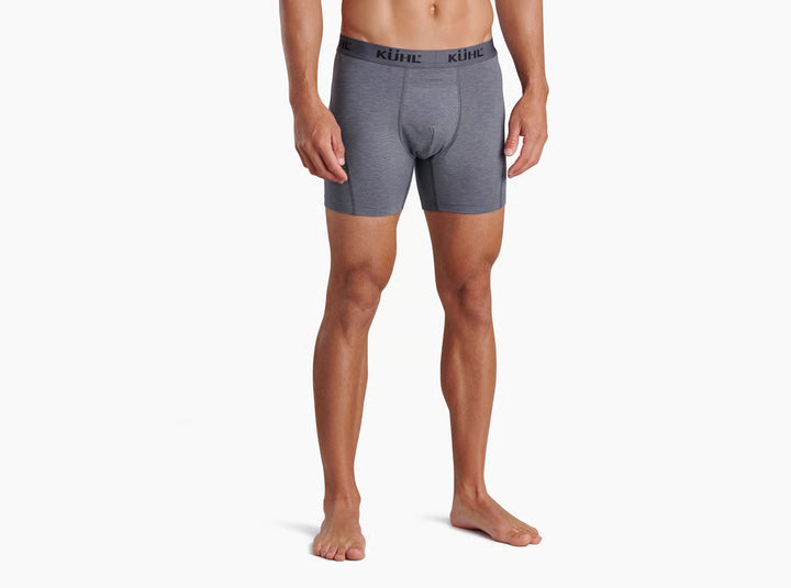 A man modeling light gray heathered boxer briefs with a black waistband featuring the KUHL logo, shown against a plain white background.