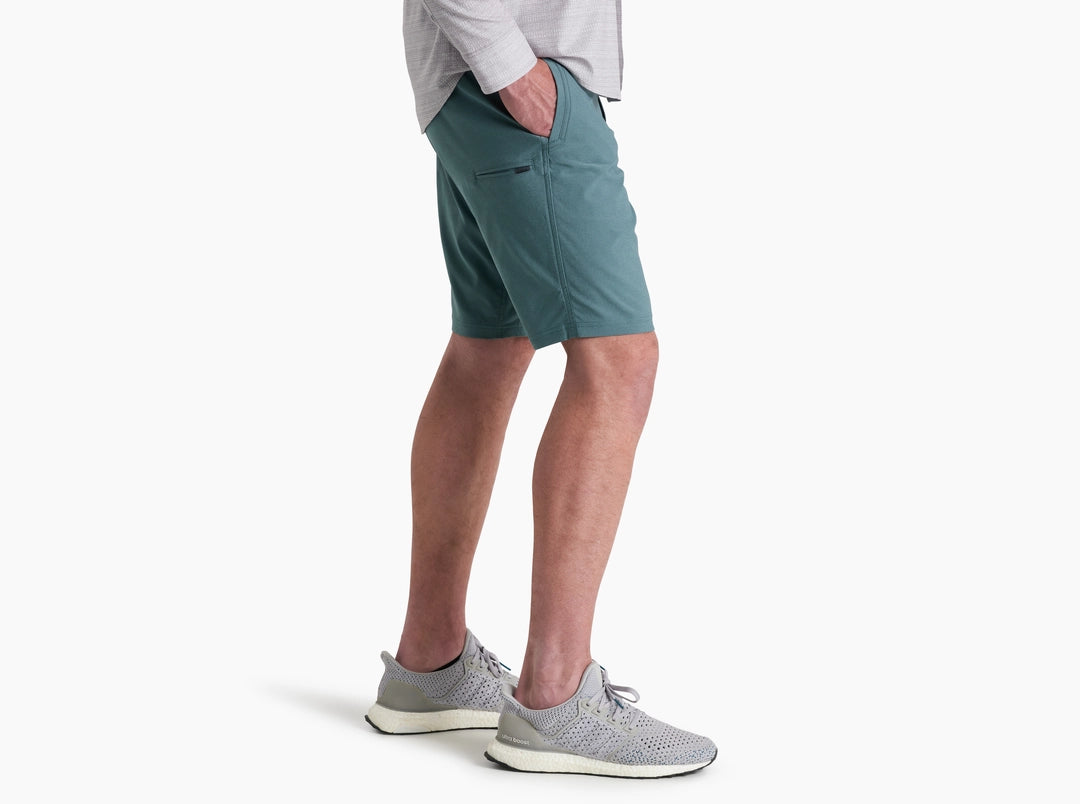 Person wearing teal shorts and gray sneakers on a white background