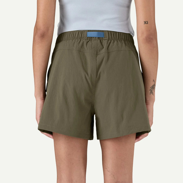 Person wearing olive green shorts on a white background