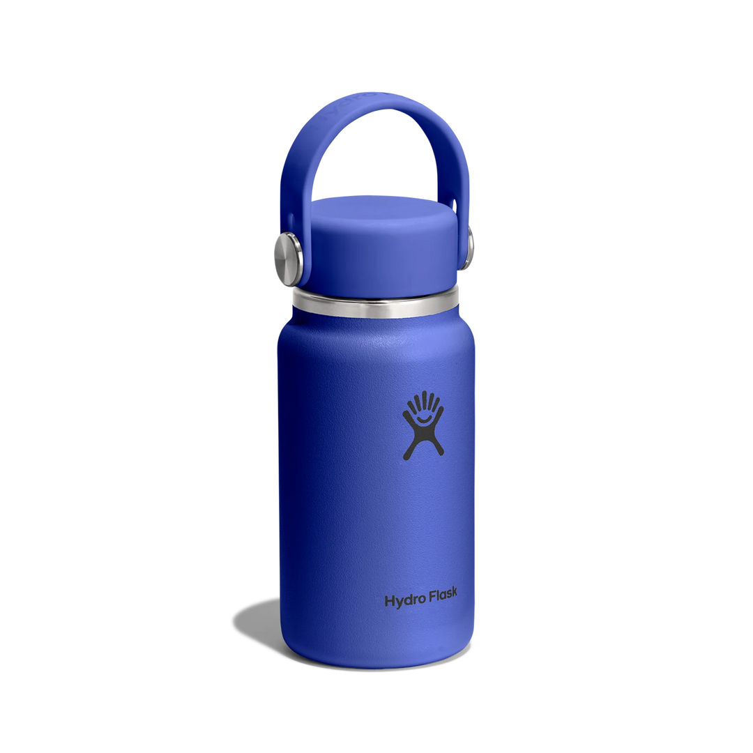 A Hydro Flask insulated water bottle in a vibrant blue color, featuring a matching blue lid with a carrying loop and a silver metal band, set against a plain white background.
