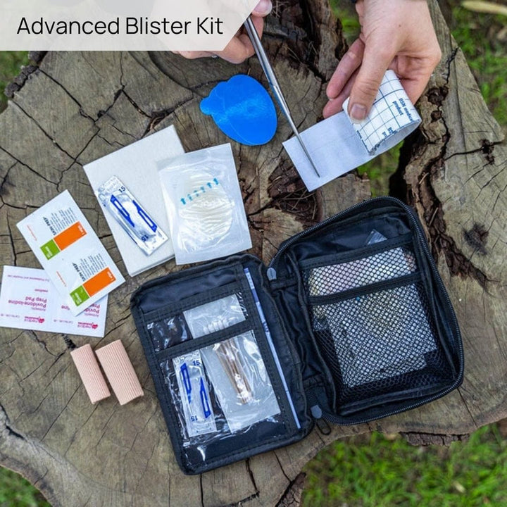First aid kit with contents spread out on a stump