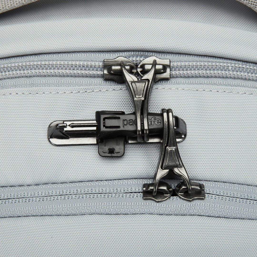 Close up of two zippers on top of a backpack showing the zip toggles clipped into a latch