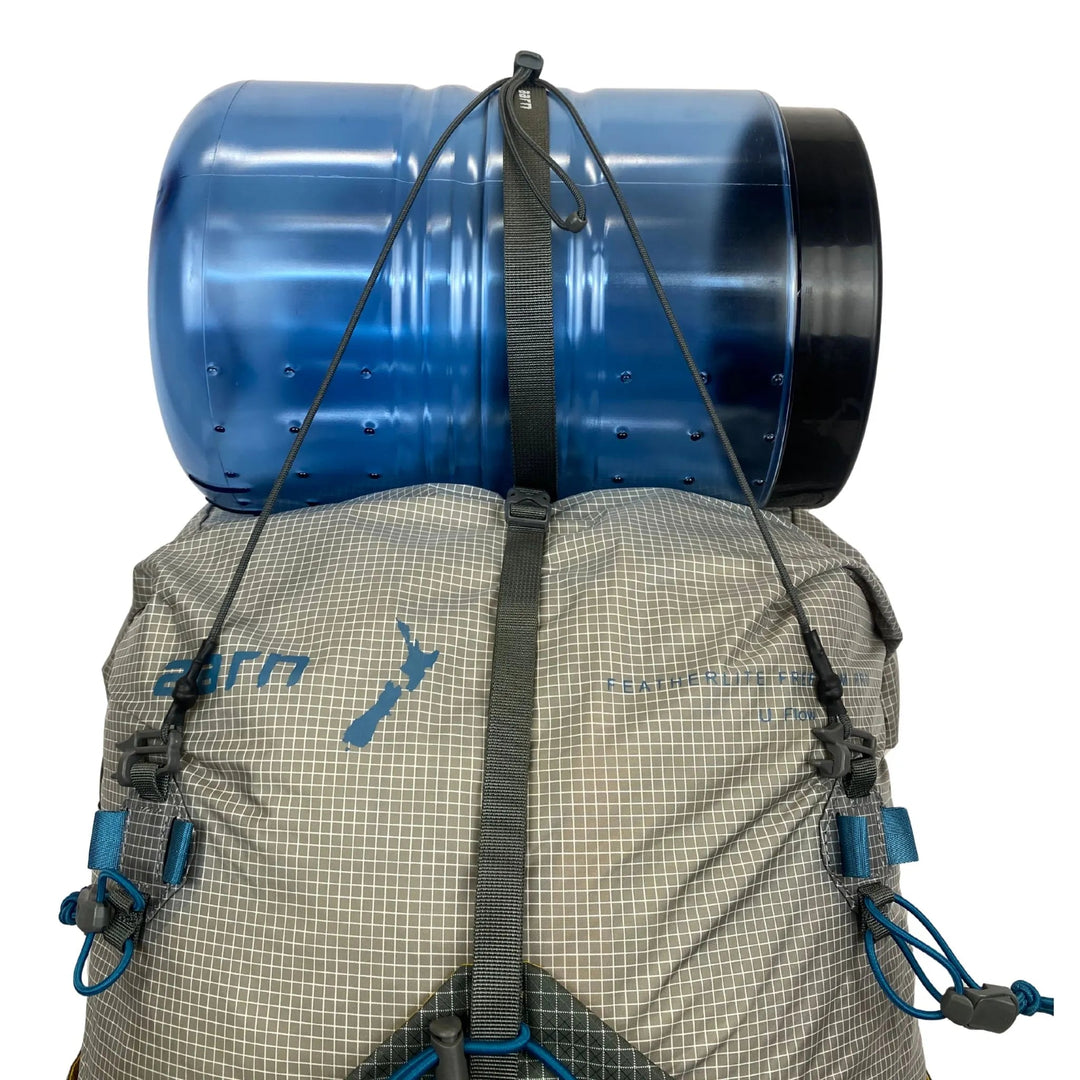 Backpack with a large blue cylindrical bear canister strapped to the back