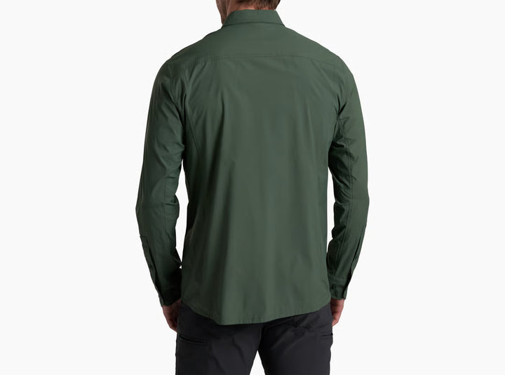 A man viewed from the back wearing a dark green long-sleeve button-up shirt and dark pants, set against a plain white background.