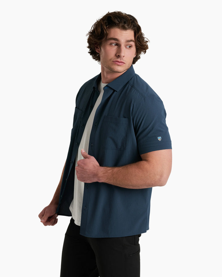 Man wearing a blue shirt over a white shirt on a white background