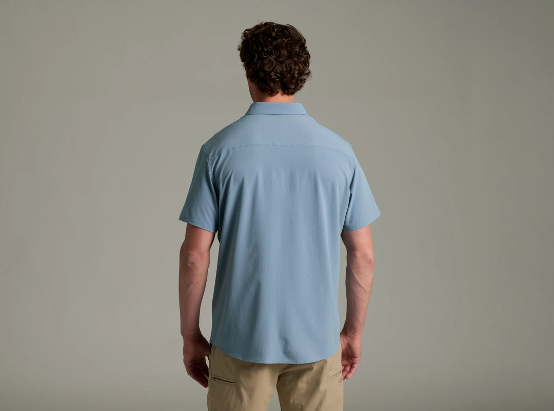 Man wearing a light blue polo shirt against a plain background