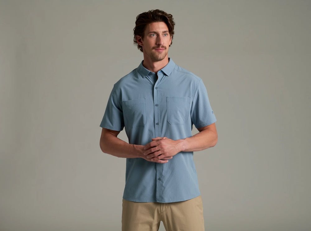 Man wearing a light blue short-sleeve shirt against a plain background