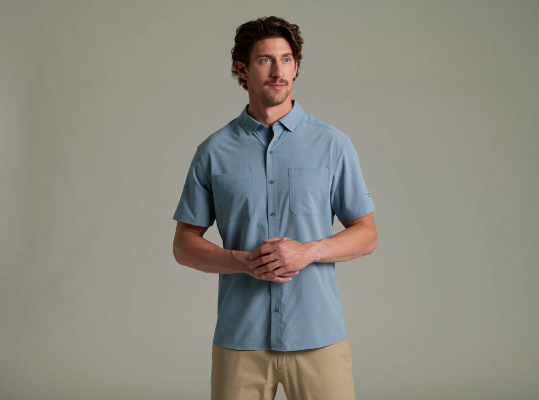 Man wearing a light blue short-sleeve shirt against a plain background