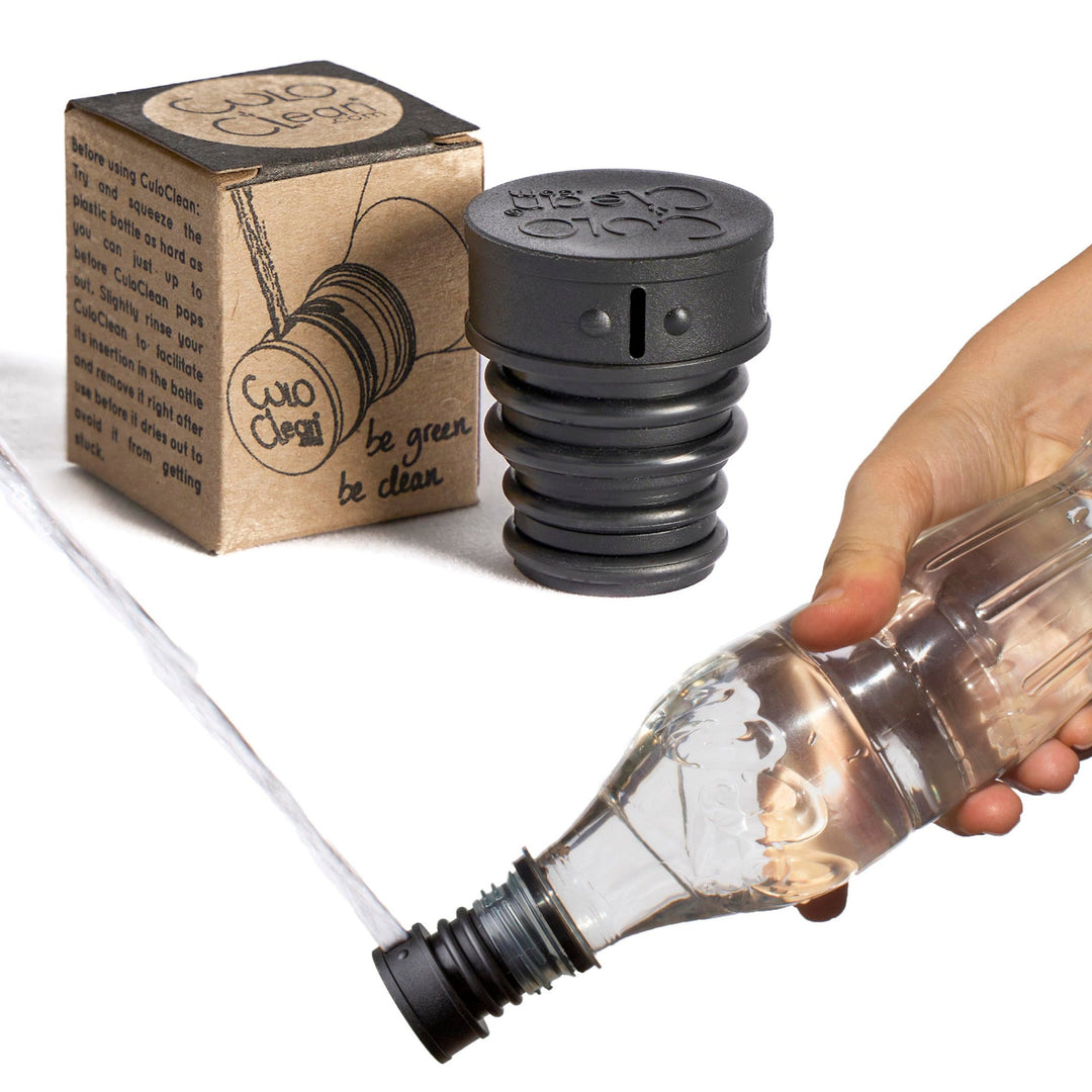 Black portable bidet screwed onto a plastic bottle and squirting water, packaging in background