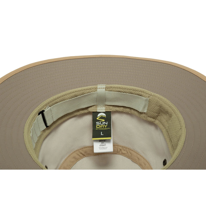 Close-up of the inside of a wide-brim sun hat, showing a beige brim, light tan fabric lining, an adjustable strap, and a hanging Sun Day afternoons tag.