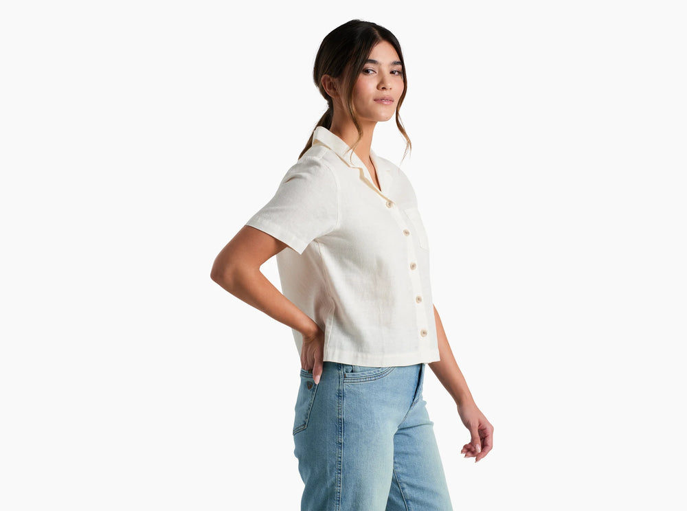 Woman wearing a white button-up shirt and blue jeans on a white background