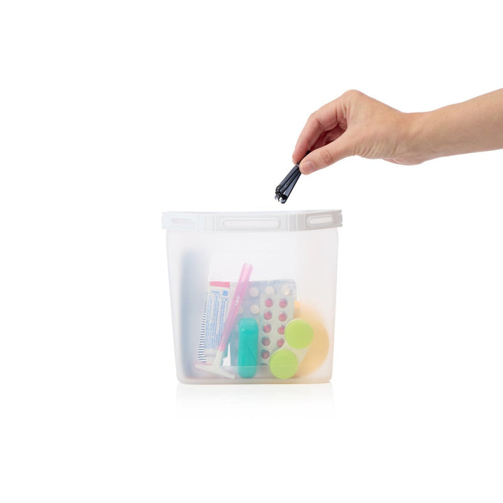 Clear pouch with stationery items held by a hand on a white background