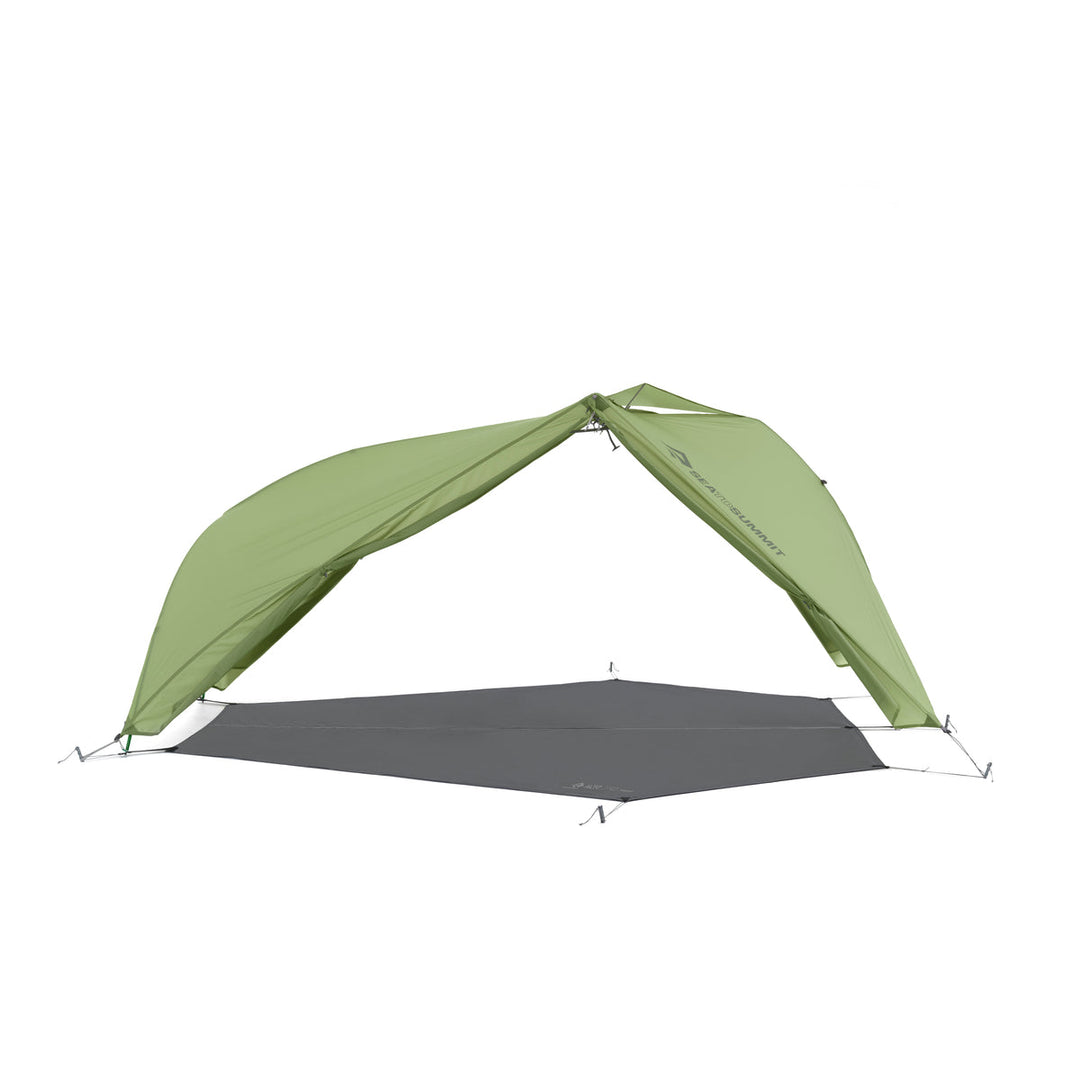 Green hiking tent fly pitched with footprint but no inner tent on a white background