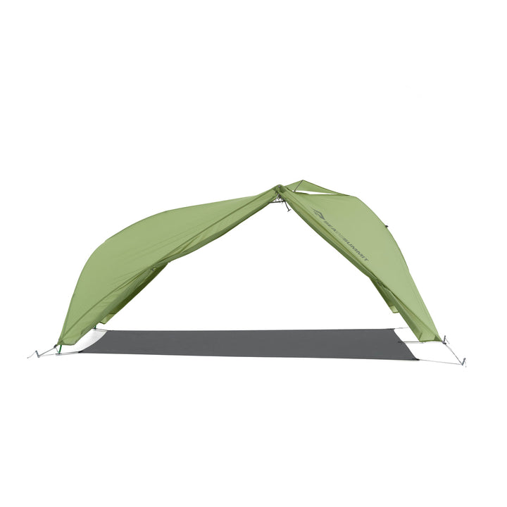 Green hiking tent fly pitched with a footprint but no inner tent on a white background