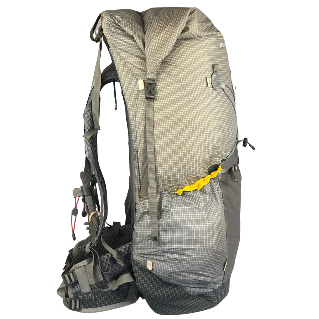Grey hiking pack viewed in profile on a white background