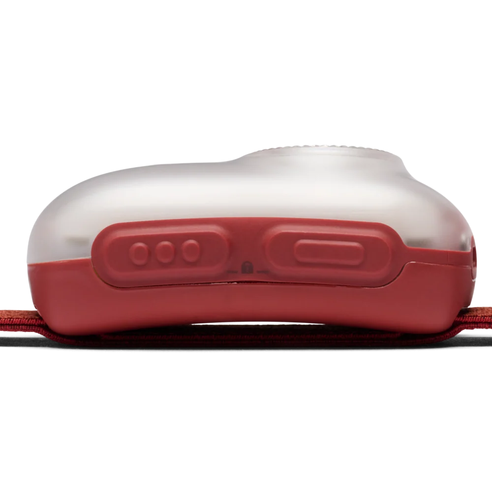 Close-up of the side of a red and translucent plastic device, likely a strap-mounted light or tracker, on a white background.