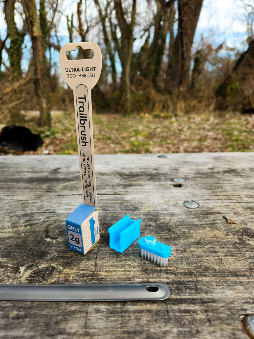 Blue toothbrush head and packaging with a natural background
