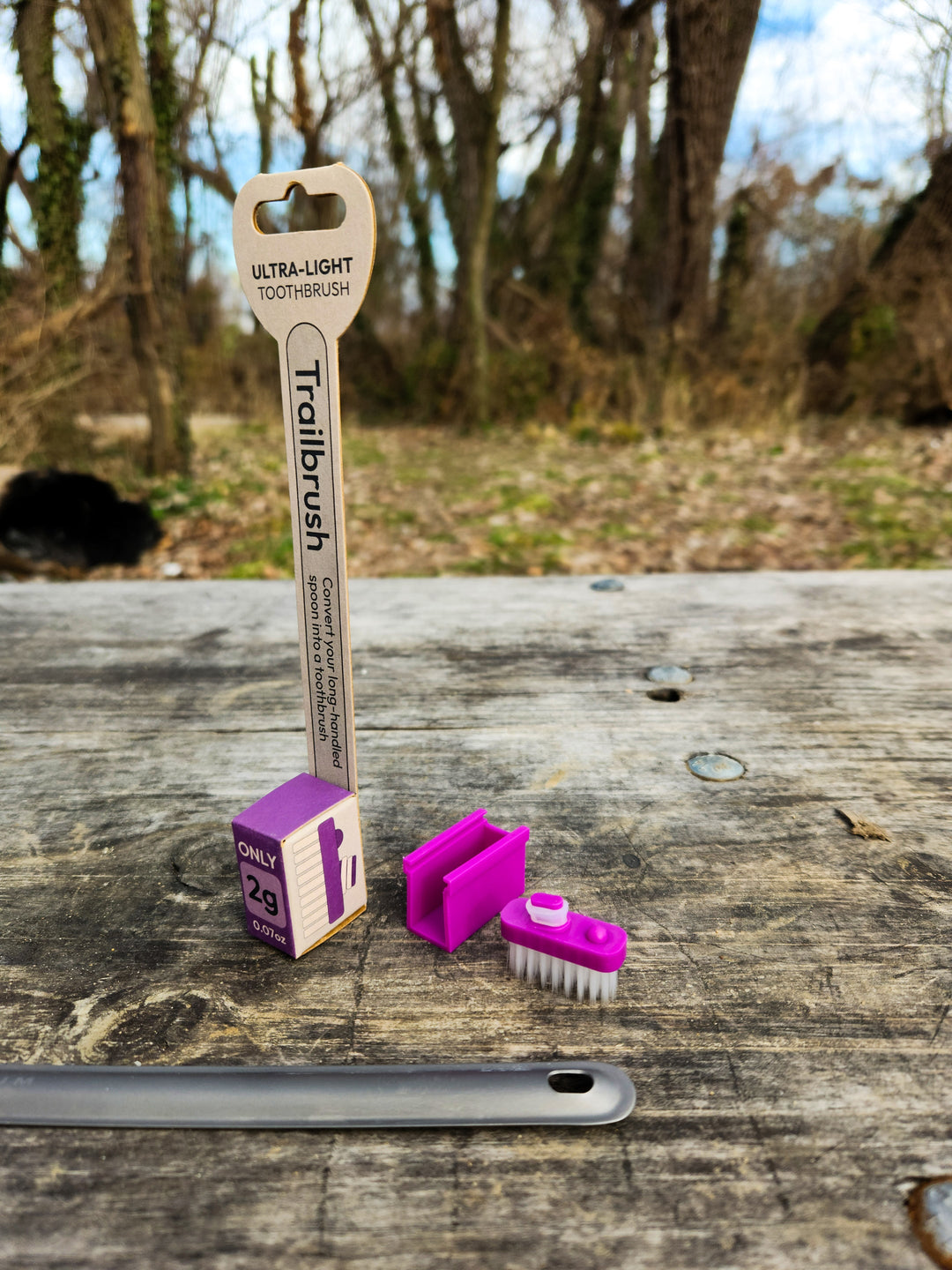 Purple toothbrush head and packaging with a natural background