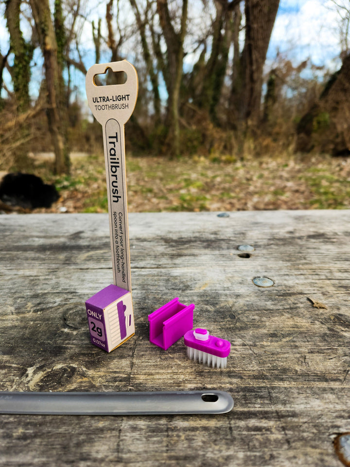 Purple toothbrush head and packaging with a natural background