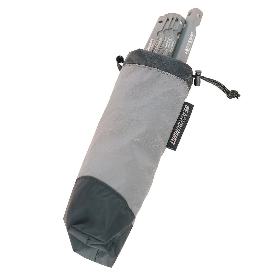 Grey pouch filled with tent pegs on a white background