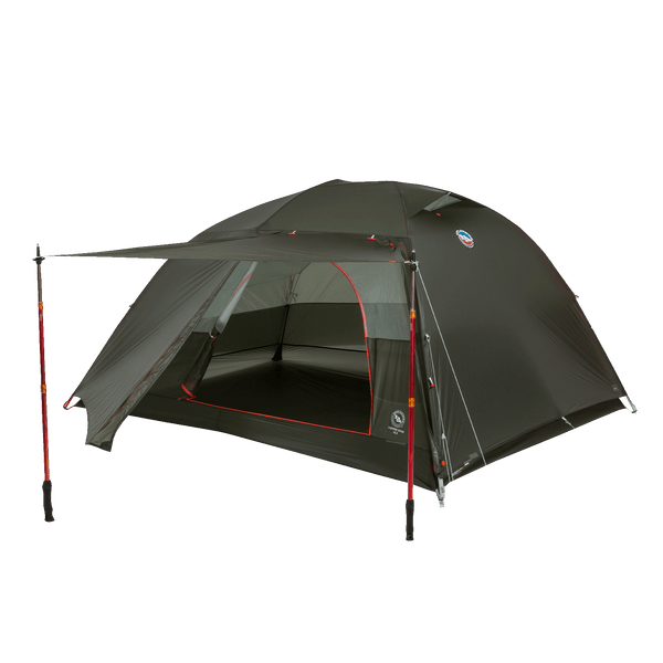 Dark green hiking tent with red detailing and an awning supported by trekking poles