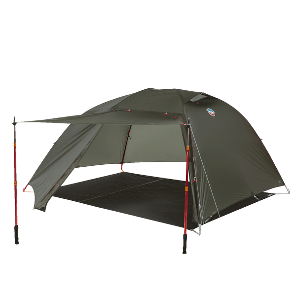 Dark green hiking tent fly with trekking pole supported awning pitched on a footprint without the inner