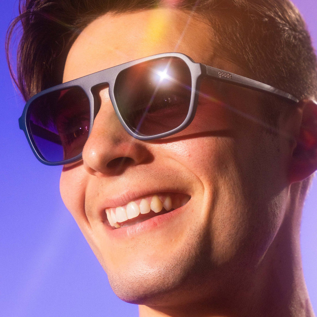 Close-up of a person wearing sunglasses with a bright blue sky background