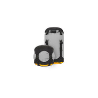 Two compression dry bags, one squished down to minimum size, one with straps loose and buckles open
