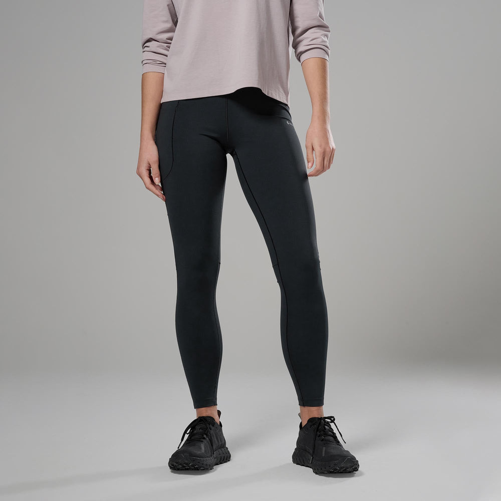 Person wearing black leggings and a light-colored top on a grey background
