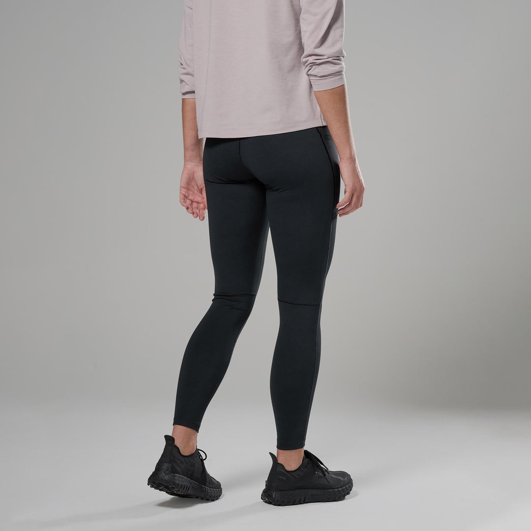 Person wearing black leggings and black shoes on a grey background