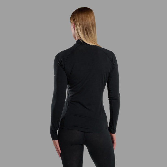 Person wearing a black long-sleeve athletic top and leggings on a gray background