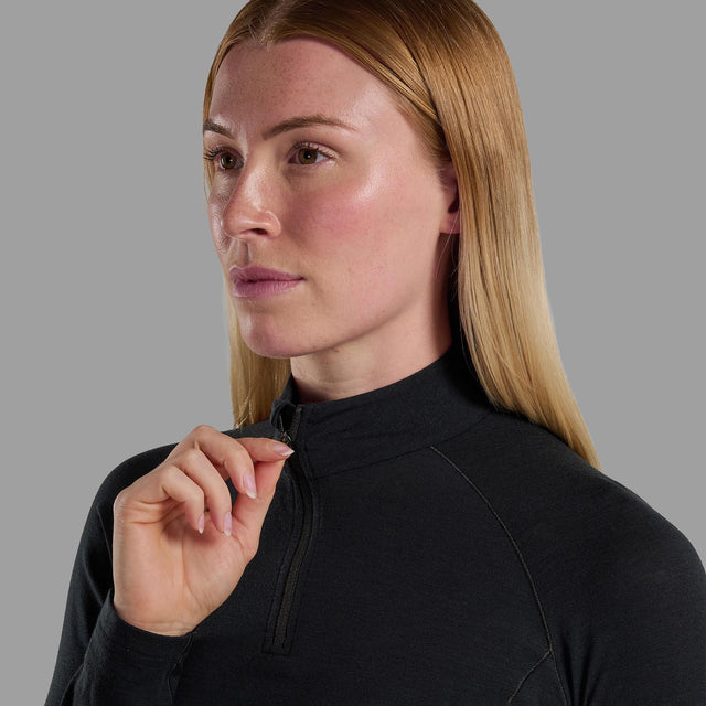 Woman wearing a black quarter-zip long sleeve against a grey background